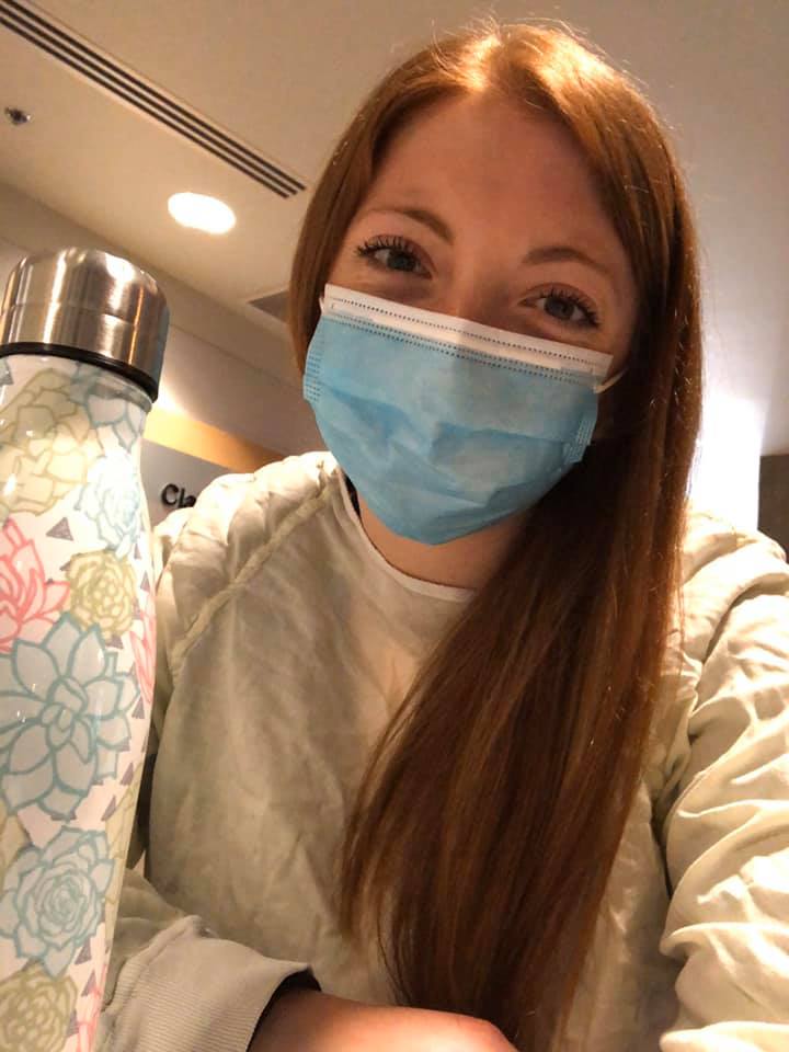 Jessika paradis souris derrière son masque en prenant une selfie au travail